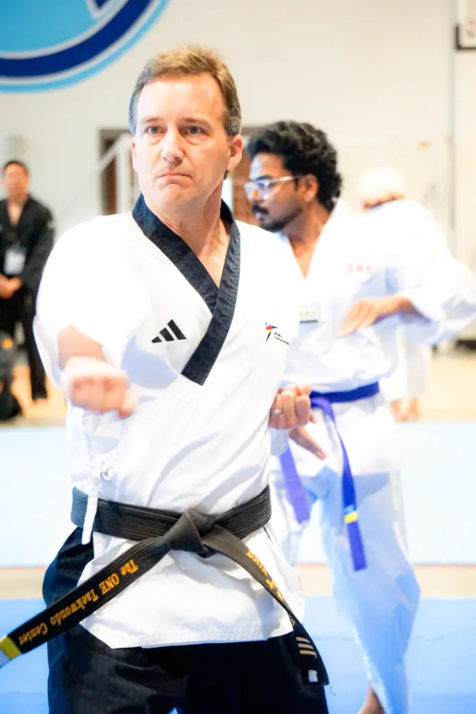Instructor guiding a young yellow belt through her kicks