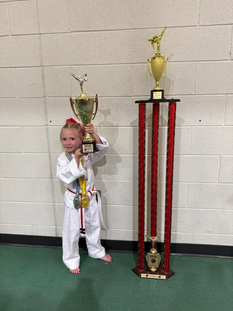 Young competitor posing with her trophies and medals