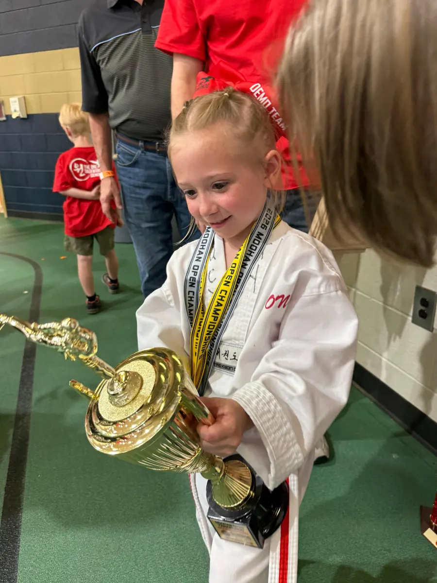 Young champion holding her trophy after competition