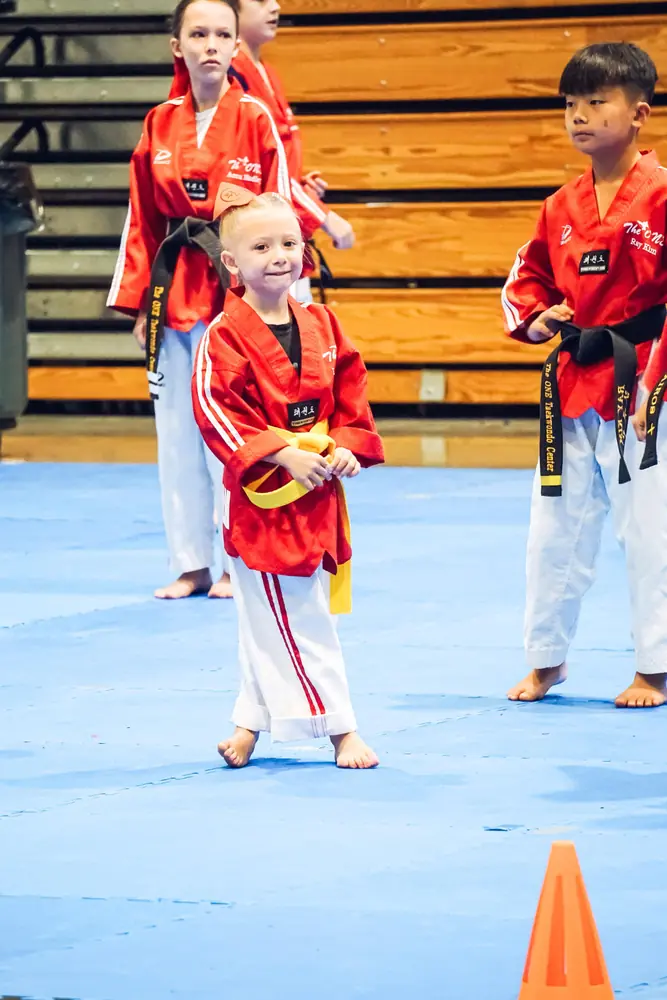 Young yellow belt student waiting on the competition mat