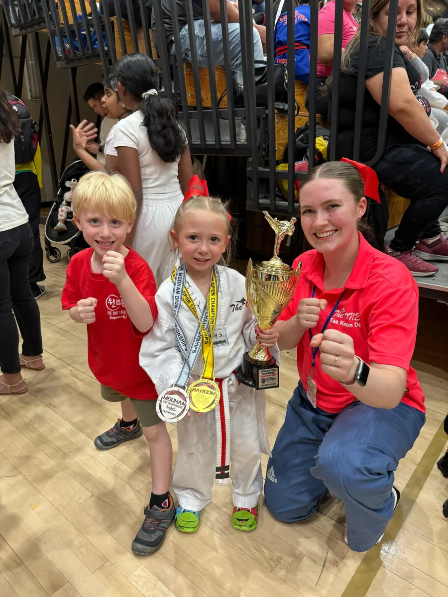 Young champion celebrating with her family and instructor